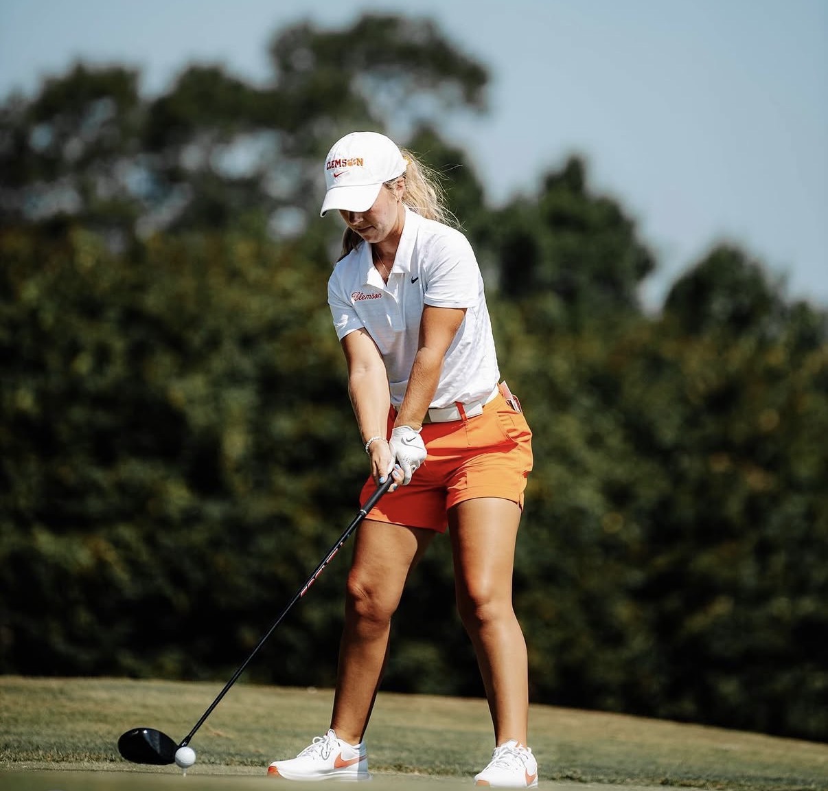 Chloe Holder hitting a tee shot in Clemson orange