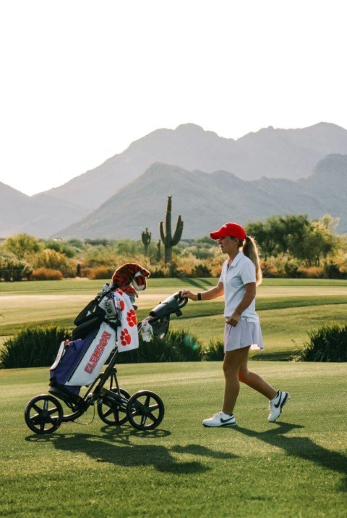 Chloe Holder walking the fairway with her Clemson golf bag