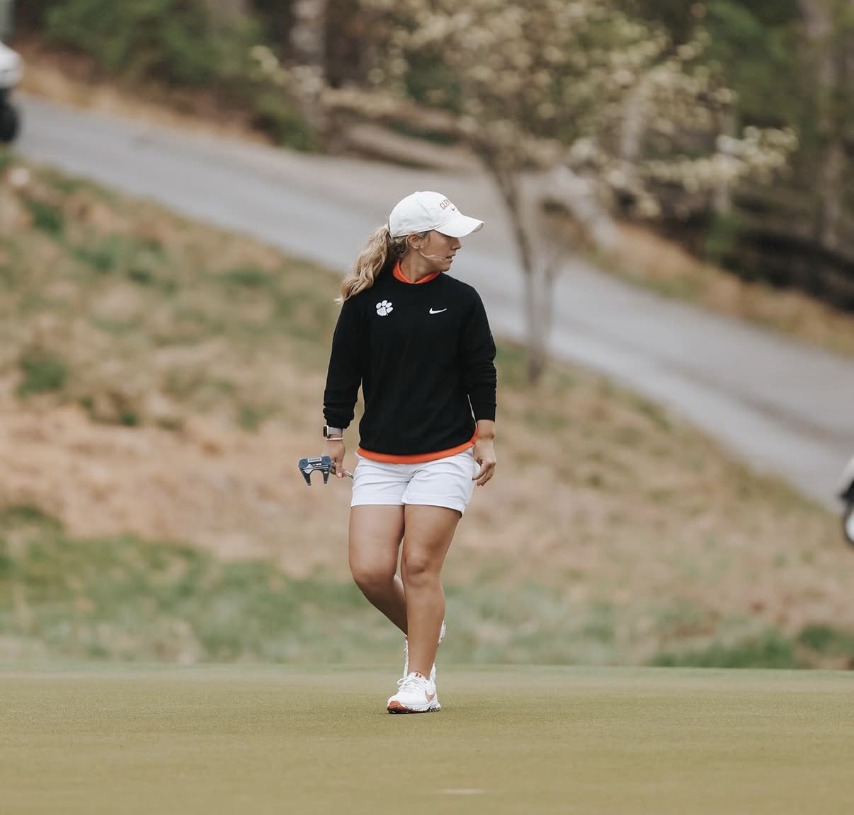 Chloe Holder walking the green with her putter